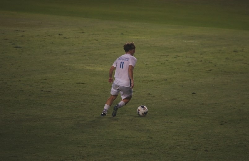 Jude Boyd #11 in Hawaii Pacific Sharks white kit dribbling at night